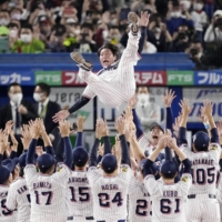 The Swallows toss manager Shingo Takatsu into the air after winning the final stage of the Central League Climax Series with a 6-3 win over the Tigers at Jingu Stadium on Friday. | KYODO