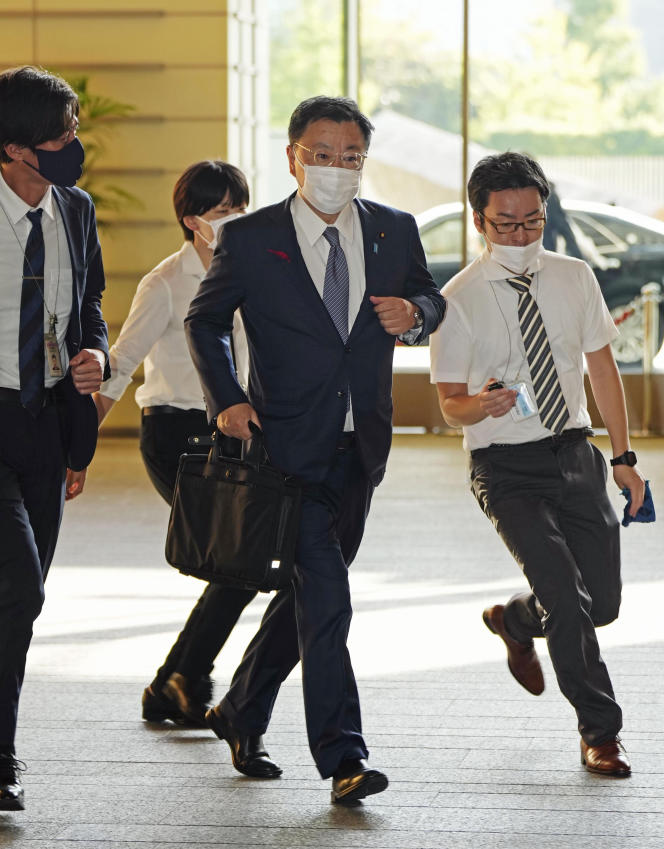 Le secrétaire général du gouvernement japonais, Hirokazu Matsuno (au centre), arrive au bureau du premier ministre, à Tokyo, le 4 octobre 2022. 