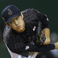 Japan starter Shintaro Fujinami pitches against an MLB All-Star team during the first inning of their game at Tokyo Dome on Nov. 16, 2014. | REUTERS
