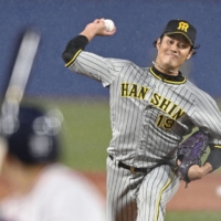 The Tigers' Shintaro Fujinami pitches against the Swallows during Game 2 of the Central League Climax Series First Stage at Jingu Stadium on Oct. 13, 2022. | KYODO 