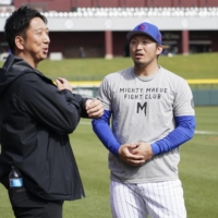 Cubs outfielder Seiya Suzuki (right) speaks with former pitcher Kyuji Fujikawa at the team's spring training camp on Sunday. | KYODO