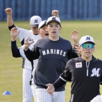 Marines pitcher Roki Sasaki (center) works out with teammates on the first day of Nippon Professional Baseball's spring training in Ishigaki, Okinawa Prefecture, on Wednesday. | KYODO
