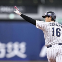 Shohei Ohtani rounds the bases after hitting a three-run home run in Samurai Japan's friendly against the Hanshin Tigers in Osaka on Monday. | KYODO
