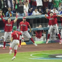 Mexico's Luis Urias returns to the dugout after hitting a three-run home run in Monday's World Baseball Classic semifinal against Japan in Miami. | KYODO