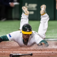 Australia's Darryl George dives into home base during the team's 12-2 win over China during the World Baseball Classic at Tokyo Dome on Saturday. | AFP-JIJI