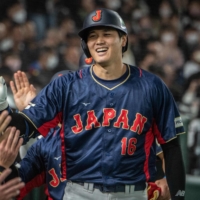 Japan's Shohei Ohtani is congratulated by his teammates after his three-run home run against Australia during the World Baseball Classic at Tokyo Dome on Sunday. | AFP-JIJI