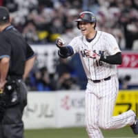 Japan's Shohei Ohtani celebrates as he rounds the bases after hitting a three-run home run against the Tigers during the third inning at Kyocera Dome Osaka on Monday. Japan won 8-1. | KYODO