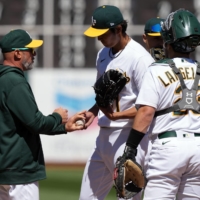 Athletics starting pitcher Shintaro Fujinami (center) hands the ball to manager Mark Kotsay in the third inning of their game against the Angels in Oakland, California, on Saturday. | USA TODAY / VIA REUTERS