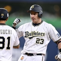 The Buffaloes' Frank Schwindel is congratulated by coach So Taguchi after his tiebreaking hit against the Eagles during the eighth inning in Osaka on Thursday. | KYODO