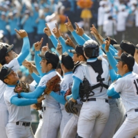 Yamanashi Gakuin players celebrate their Spring Koshien championship after beating Hotoku Gakuen in Nishinomiya, Hyogo Prefecture, on Saturday. | KYODO