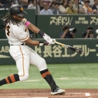 The Giants' Adam Walker hits a two-run homer against the Dragons at Tokyo Dome on Sunday. | KYODO