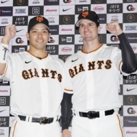 Giants pitcher Foster Griffin (right) and catcher Takumi Oshiro pose for photos after their hero interview at Tokyo Dome on Saturday. | KYODO