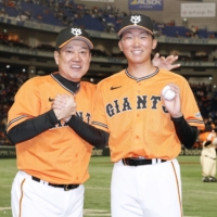 Giants pitcher Chiharu Tanaka (right) poses with manager Tatsunori Hara after earning the first win of his career at Tokyo Dome on Thursday. | KYODO