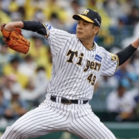 Kotaro Otake pitches to his fifth win of the season for the Tigers against the BayStars in Nishinomiya, Hyogo Prefecture, on Saturday. | KYODO