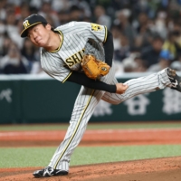 Tigers rookie Shoki Murakami pitches against the Lions on the opening day of interleague play in Tokorozawa, Saitama Prefecture, on Tuesday. | KYODO
