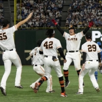The Giants celebrate after Kazuma Okamoto's walk-off double against the Fighters on Saturday. | KYODO