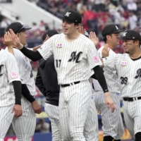 Roki Sasaki (No. 17) and his Lotte teammates celebrate their win over the Carp at Zozo Marine Stadium in Chiba on Sunday. | KYODO