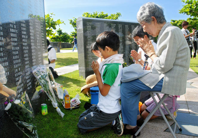 Une famille se recueille devant une stèle portant les noms de Japonais et d’Américains morts lors de la bataille d’Okinawa, au mémorial pour la paix d’Itoman, le 23 juin 2007.