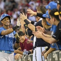 The Pacific League's Chusei Mannami is congratulated by his teammates after his home run during Game 2 of NPB's All-Star series in Hiroshima on Thursday. | KYODO