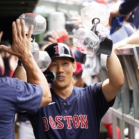 Masataka Yoshida celebrates in the dugout after hitting a grand slam against the Cubs in Chicago on Sunday. | USA TODAY / VIA REUTERS