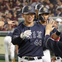 Orix's Yuma Tongu (center) returns to the dugout after his first-inning grand slam against the Eagles at Tokyo Dome on Tuesday. | KYODO
