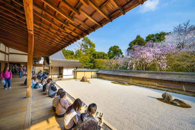 Des touristes devant les cerisiers de printemps, au temple Ryoan-ji, à Kyoto, au Japon, le 9 avril 2014.