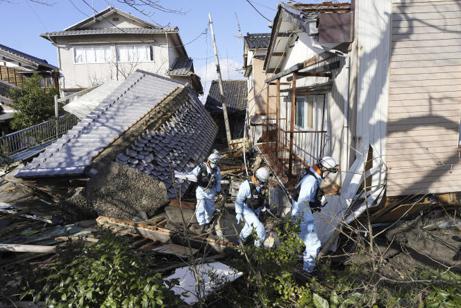 Des pompiers au milieu de maisons détruites par les tremblements de terre, à Suzu, au Japon, le 4 janvier 2024.