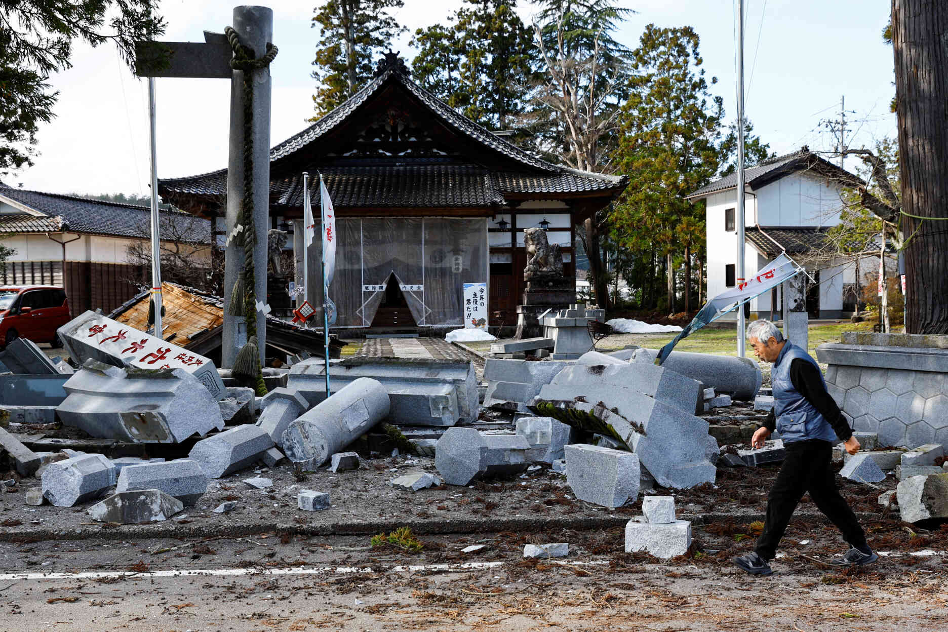 Un homme passe devant un sanctuaire endommagé à Ujima, dans la préfecture d’Ishikawa, au Japon, le 2 janvier 2024.