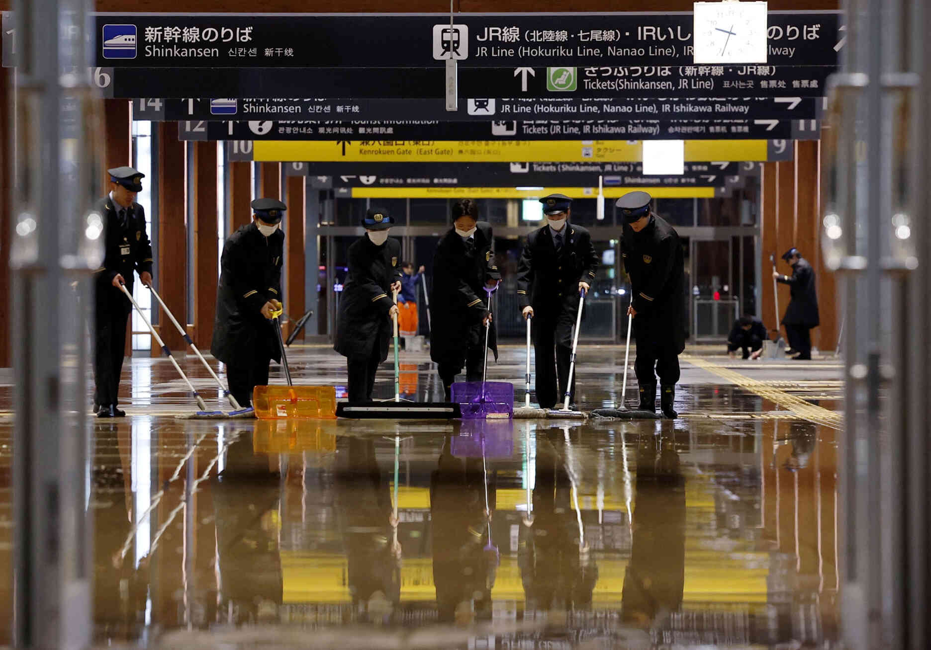 Des cheminots évacuent l’eau à la suite de canalisations rompues à la gare de Kanazawa, la capitale de la préfecture d’Ishikawa, au Japon, le 1ᵉʳ janvier 2024.