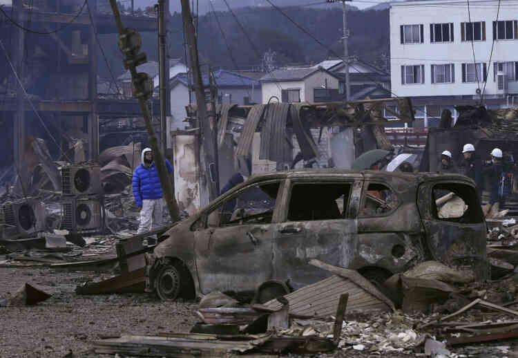 Une voiture brûlée et des débris sur la place du marché à Wajima, dans la préfecture d’Ishikawa, au Japon, le 2 janvier 2024. 