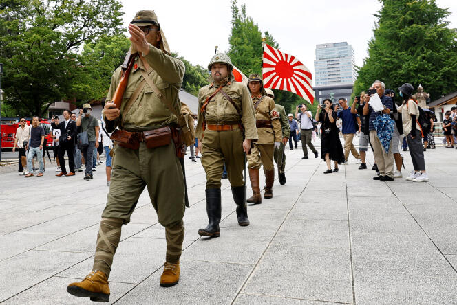 Des personnes portant l’uniforme militaire impérial japonais et arborant le Kyokujitsuki, le « drapeau du Soleil-Levant », au sanctuaire Yasukuni, à l’occasion du 78ᵉ anniversaire de la capitulation du Japon à la fin de la seconde guerre mondiale, à Tokyo, le 15 août 2023.
