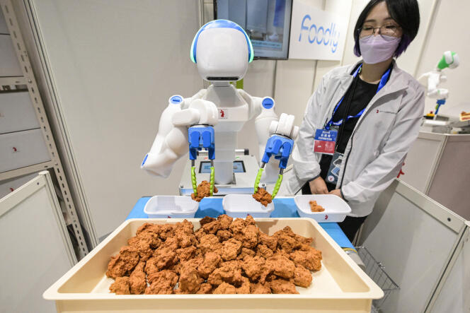 Un robot trie et place des morceaux de poulet frit dans des boites, lors de l’Exposition internationale de robots, au centre d’exposition international de Tokyo (Japon), le 29 novembre 2023.